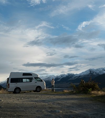 Een kleine foto van een camper met mooie blauwe lucht 