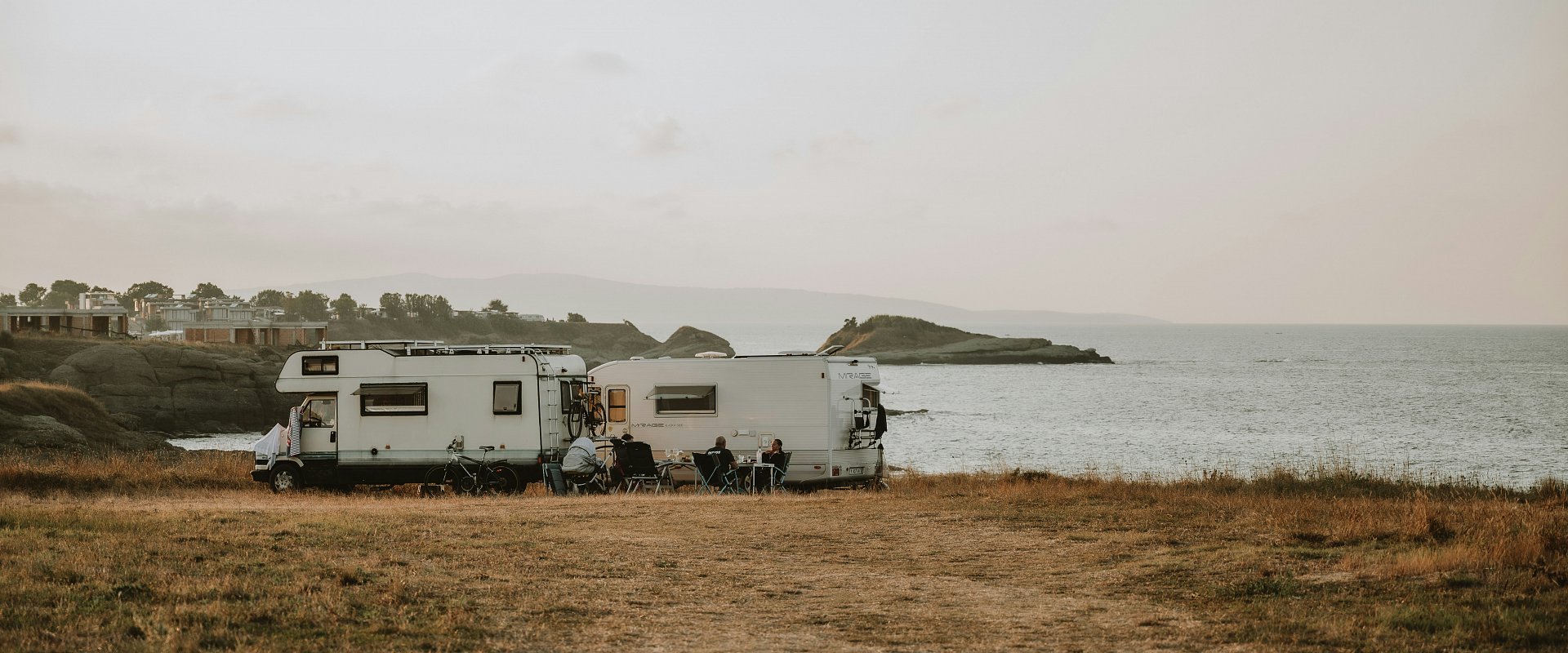 Een landschapsbeeld met twee campers aan het water